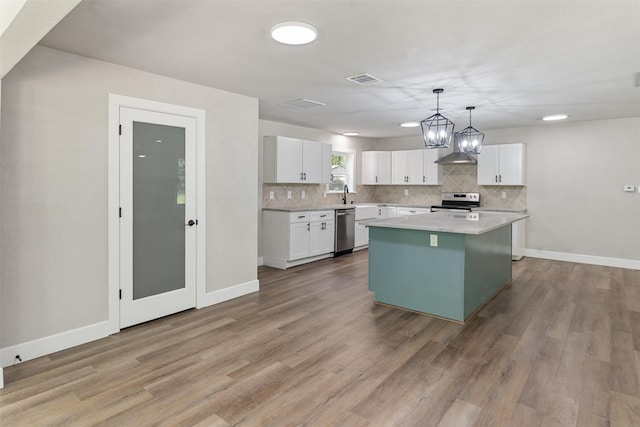 147 Carolynn Rd, Mabank, TX 75156 - kitchen featuring appliances with stainless steel finishes, backsplash, white cabinets, light countertops, and light wood finished floors
