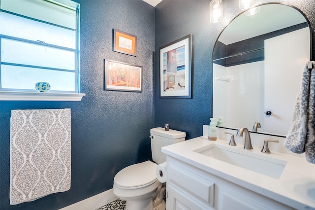 1905 Red Cypress Ct, Arlington, TX 76012 - bathroom featuring a textured wall, vanity, toilet, and a shower