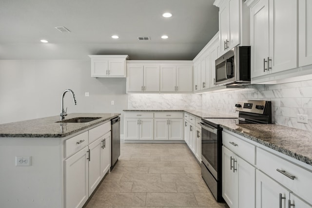 129 Braves Way, Lavon, TX 75166 - kitchen with appliances with stainless steel finishes, a sink, tasteful backsplash, white cabinetry, and recessed lighting