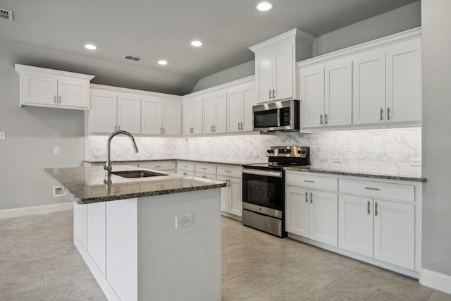 129 Braves Way, Lavon, TX 75166 - kitchen with stainless steel appliances, a sink, dark stone counters, backsplash, and white cabinets