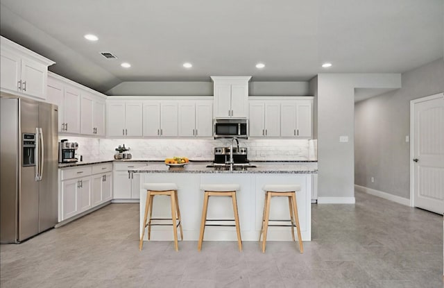 129 Braves Way, Lavon, TX 75166 - kitchen with appliances with stainless steel finishes, backsplash, a sink, a breakfast bar area, and white cabinets