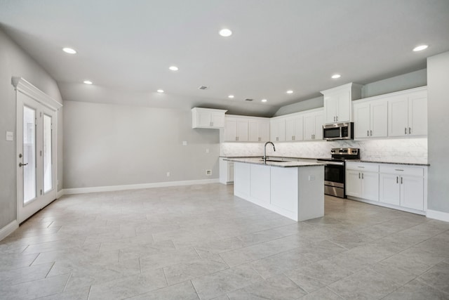 129 Braves Way, Lavon, TX 75166 - kitchen featuring appliances with stainless steel finishes, a sink, tasteful backsplash, an island with sink, and white cabinetry