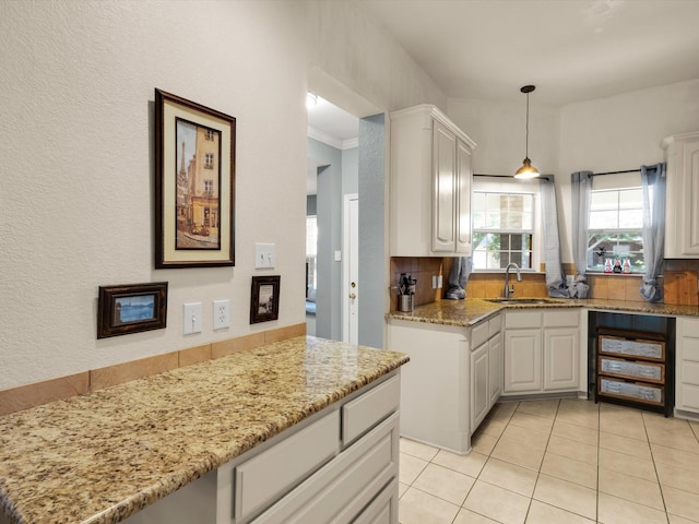 3401 Muleshoe Ln, Fort Worth, TX 76179 - kitchen with a sink, light tile patterned flooring, light stone counters, decorative light fixtures, and white cabinets