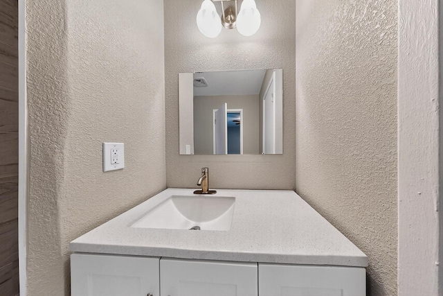 6821 Mickey Dr, Watauga, TX 76148 - bathroom with a textured wall, vanity, and a chandelier