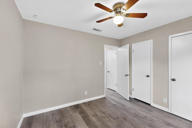 6821 Mickey Dr, Watauga, TX 76148 - unfurnished bedroom with wood finished floors, baseboards, and a ceiling fan
