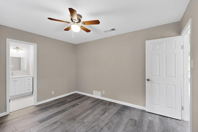 6821 Mickey Dr, Watauga, TX 76148 - unfurnished bedroom with wood finished floors, baseboards, ceiling fan, and connected bathroom