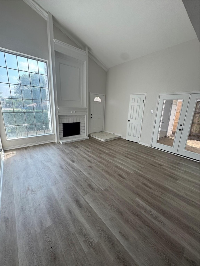 4831 Spindrift, Garland, TX 75043 - unfurnished living room featuring vaulted ceiling, a fireplace, dark wood-type flooring, french doors, and baseboards