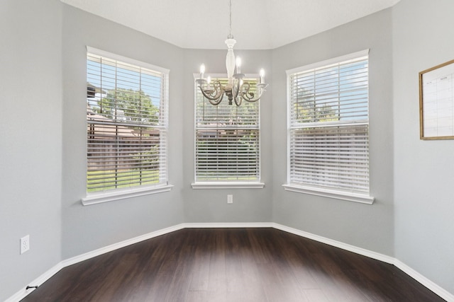 7314 Glenstone St, Rowlett, TX 75089 - unfurnished dining area with a chandelier, healthy amount of natural light, dark wood-type flooring, and baseboards