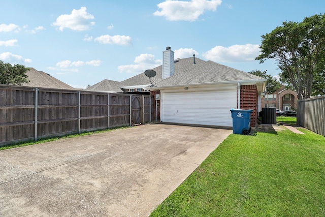 7314 Glenstone St, Rowlett, TX 75089 - back of house with brick siding, roof with shingles, central AC unit, a chimney, and driveway