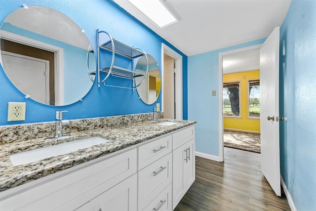 1200 Old Decatur Rd, Decatur, TX 76234 - bathroom featuring wood finished floors, double vanity, and baseboards