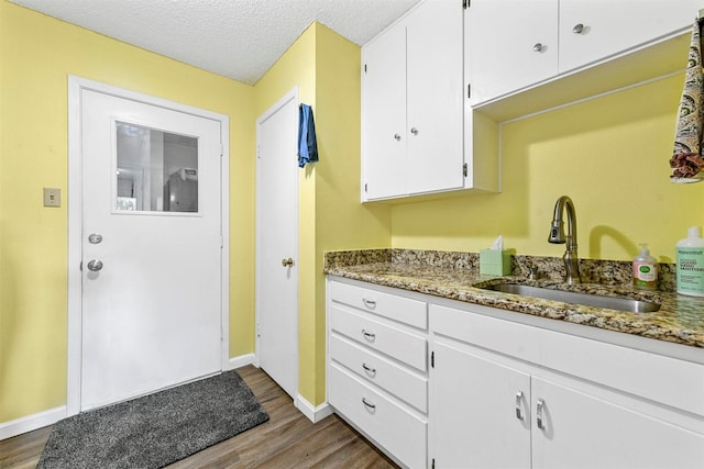 1200 Old Decatur Rd, Decatur, TX 76234 - washroom featuring a sink, dark wood-type flooring, baseboards, and a textured ceiling