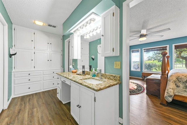 1200 Old Decatur Rd, Decatur, TX 76234 - ensuite bathroom with vanity, a textured ceiling, a ceiling fan, wood finished floors, and baseboards