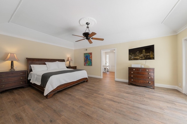 6867 Mossvine Dr, Dallas, TX 75254 - bedroom featuring wood finished floors, baseboards, a tray ceiling, a ceiling fan, and crown molding