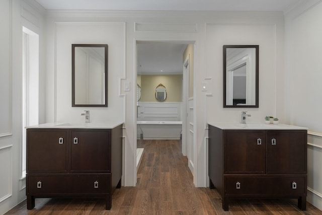 6867 Mossvine Dr, Dallas, TX 75254 - full bathroom featuring two vanities and wood finished floors
