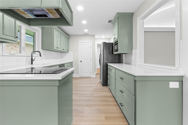 5305 Links Dr, Waco, TX 76708 - kitchen featuring green cabinets, black electric cooktop, recessed lighting, light wood-style floors, and decorative backsplash