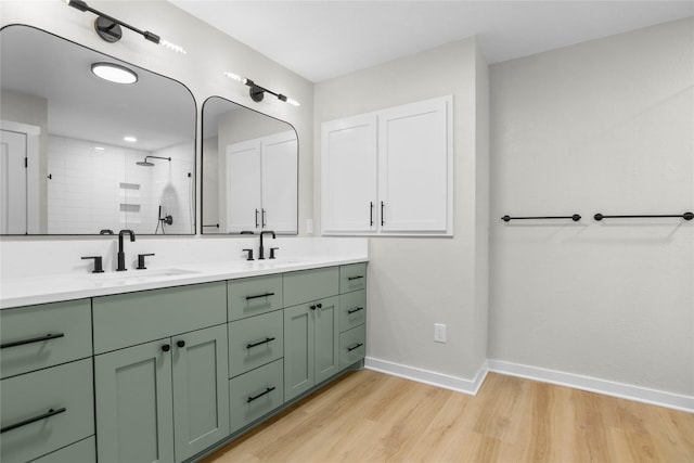 5305 Links Dr, Waco, TX 76708 - bathroom with double vanity, tiled shower, wood finished floors, and baseboards