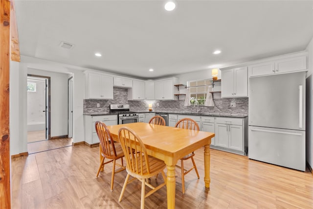 201 W Tinsley Dr, Robinson, TX 76706 - kitchen featuring stainless steel appliances, open shelves, a sink, decorative backsplash, and white cabinets