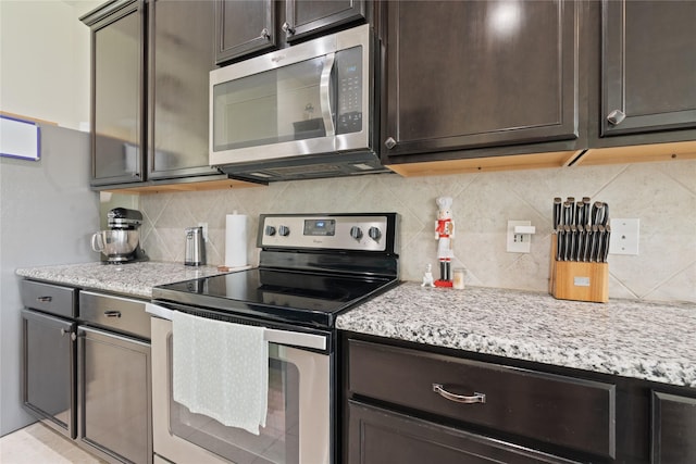 2014 Autumn Dr, Glenn Heights, TX 75154 - kitchen with stainless steel appliances, dark brown cabinetry, decorative backsplash, light stone counters, and glass insert cabinets