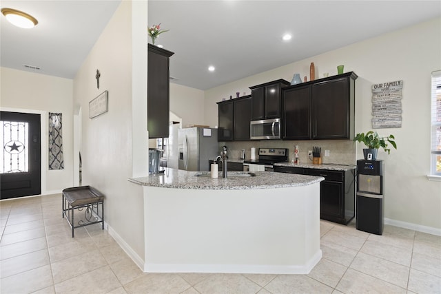 2014 Autumn Dr, Glenn Heights, TX 75154 - kitchen with appliances with stainless steel finishes, light stone counters, light tile patterned flooring, a peninsula, and recessed lighting
