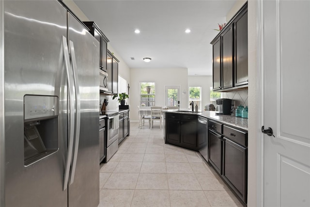2014 Autumn Dr, Glenn Heights, TX 75154 - kitchen with stainless steel appliances, recessed lighting, light tile patterned floors, a peninsula, and decorative backsplash