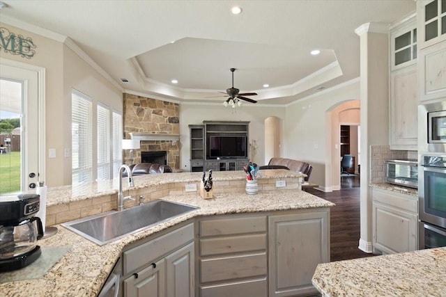 7030 Brooke Blvd, Midlothian, TX 76065 - kitchen with open floor plan, a sink, a tray ceiling, crown molding, and arched walkways
