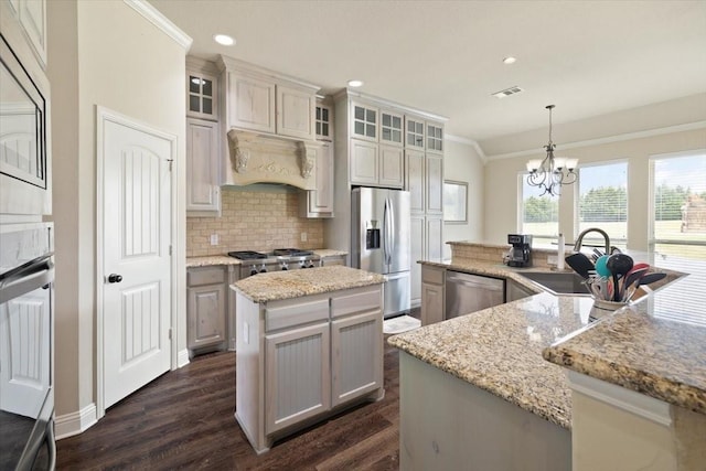 7030 Brooke Blvd, Midlothian, TX 76065 - kitchen featuring appliances with stainless steel finishes, a center island with sink, a sink, backsplash, and dark wood-style floors