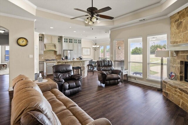 7030 Brooke Blvd, Midlothian, TX 76065 - living area with a tray ceiling, a stone fireplace, a ceiling fan, crown molding, and dark wood finished floors