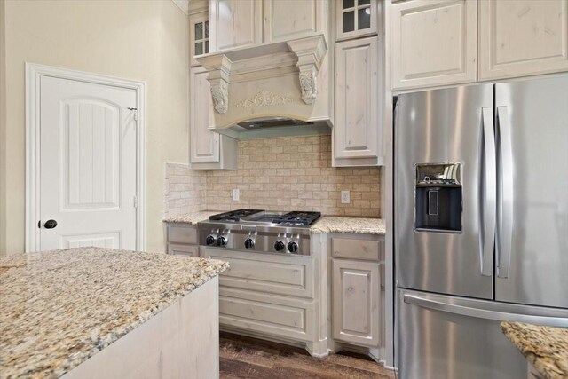 7030 Brooke Blvd, Midlothian, TX 76065 - kitchen featuring appliances with stainless steel finishes, custom exhaust hood, glass insert cabinets, and light stone counters