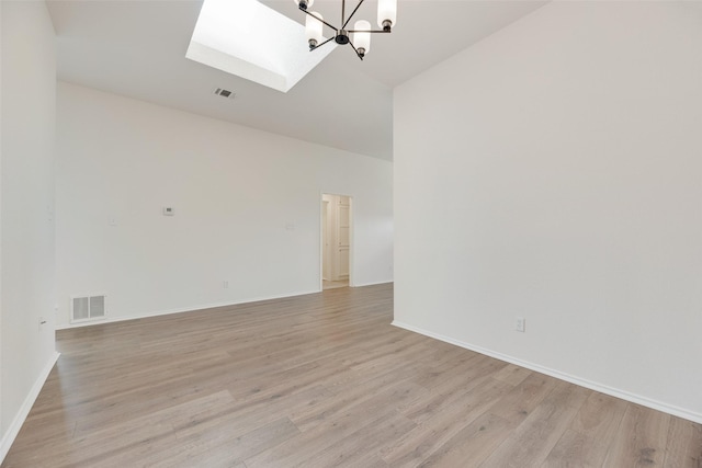 2018 Hearthside Ln, Garland, TX 75044 - spare room featuring a skylight, a chandelier, light wood finished floors, baseboards, and high vaulted ceiling