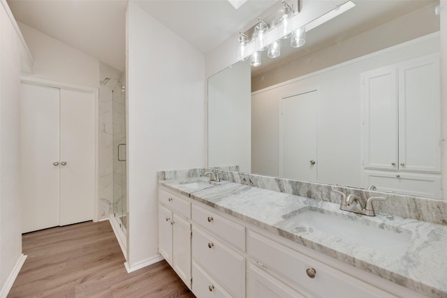 2018 Hearthside Ln, Garland, TX 75044 - full bath with double vanity, a shower stall, wood finished floors, and baseboards