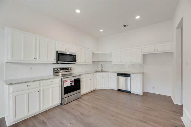 2018 Hearthside Ln, Garland, TX 75044 - kitchen featuring stainless steel appliances, a sink, open shelves, white cabinets, and backsplash