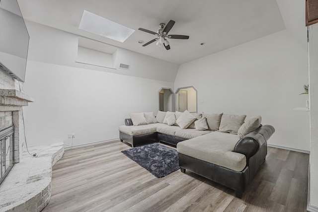 4612 Applewood Rd, Fort Worth, TX 76133 - living area with lofted ceiling, ceiling fan, a fireplace, wood finished floors, and a skylight