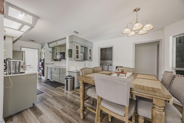 4612 Applewood Rd, Fort Worth, TX 76133 - dining space featuring separate washer and dryer, a chandelier, and dark wood-type flooring