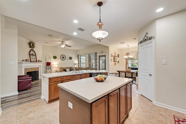 11808 Warbler Ln, Fort Worth, TX 76244 - kitchen featuring a sink, a center island, open floor plan, a fireplace, and light tile patterned floors