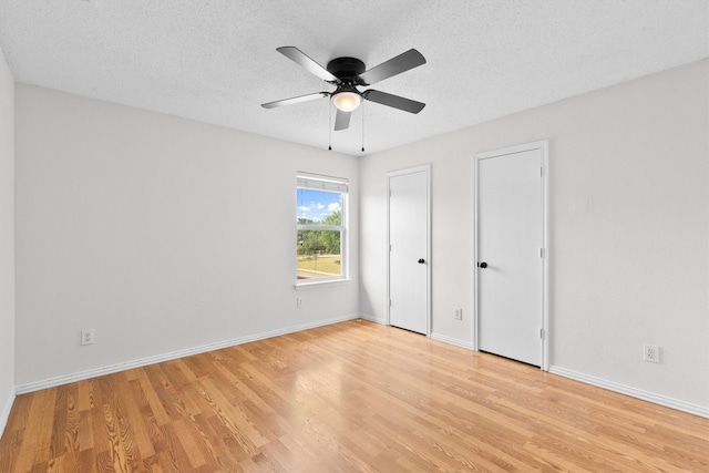 1800 Summer Glen Ct, Allen, TX 75002 - unfurnished bedroom with light wood-style floors, multiple closets, baseboards, a ceiling fan, and a textured ceiling