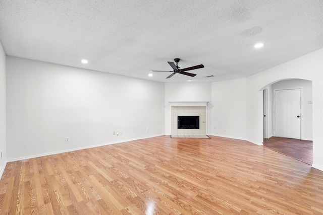 1800 Summer Glen Ct, Allen, TX 75002 - unfurnished living room featuring arched walkways, a ceiling fan, light wood-style flooring, recessed lighting, and a textured ceiling