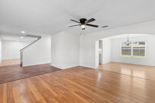 1800 Summer Glen Ct, Allen, TX 75002 - unfurnished living room with a ceiling fan, arched walkways, stairs, a chandelier, and light wood-style floors