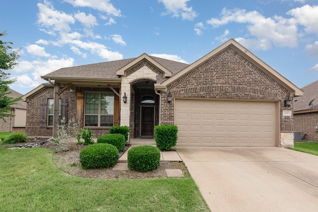 269 Arbury Dr, Forney, TX 75126 - view of front facade featuring brick siding, an attached garage, driveway, a front yard, and roof with shingles