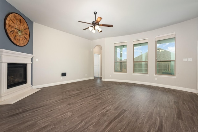 269 Arbury Dr, Forney, TX 75126 - unfurnished living room featuring dark wood-style floors, lofted ceiling, ceiling fan, a glass covered fireplace, and arched walkways