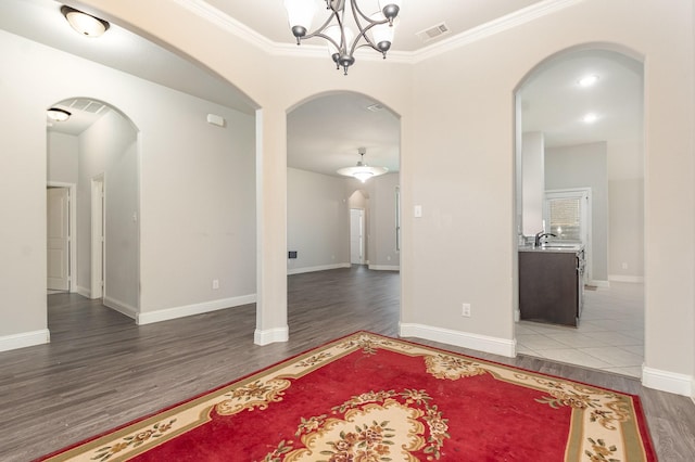 269 Arbury Dr, Forney, TX 75126 - empty room with arched walkways, wood finished floors, a chandelier, and crown molding