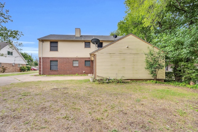 1211 Plateau Dr, Duncanville, TX 75116 - rear view of house with brick siding, a chimney, and a yard
