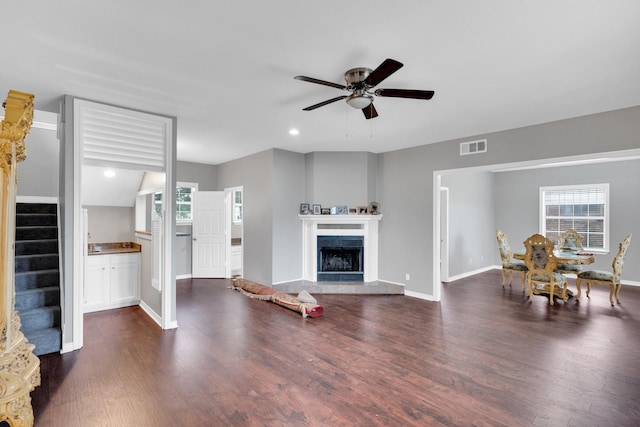 1211 Plateau Dr, Duncanville, TX 75116 - living room with a ceiling fan, dark wood-type flooring, stairway, baseboards, and a fireplace with raised hearth
