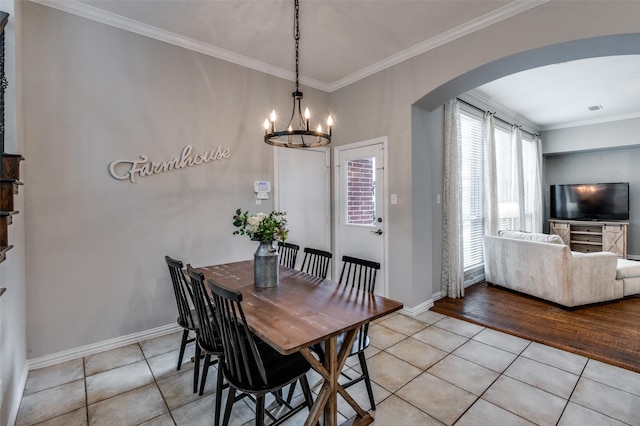 439 Fox Trl, Allen, TX 75002 - dining area featuring arched walkways, a chandelier, light tile patterned flooring, crown molding, and baseboards