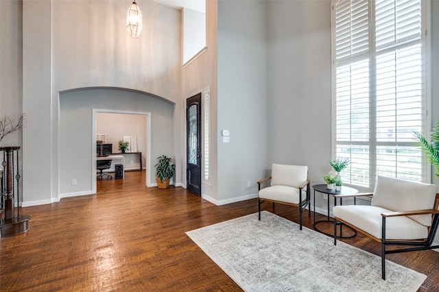 439 Fox Trl, Allen, TX 75002 - living area with a high ceiling, wood finished floors, baseboards, and arched walkways