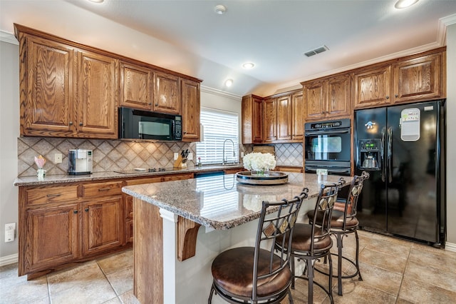 417 Fox Trl, Allen, TX 75002 - kitchen with black appliances, lofted ceiling, light stone countertops, brown cabinets, and ornamental molding