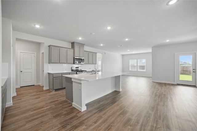 809 Vineyard Way, Forney, TX 75126 - kitchen featuring stainless steel appliances, gray cabinetry, dark wood-type flooring, an island with sink, and a sink