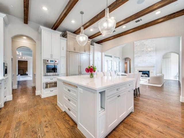 1545 Silver Creek Cir, Lucas, TX 75002 - kitchen featuring stainless steel oven, a warming drawer, arched walkways, white cabinetry, and beam ceiling
