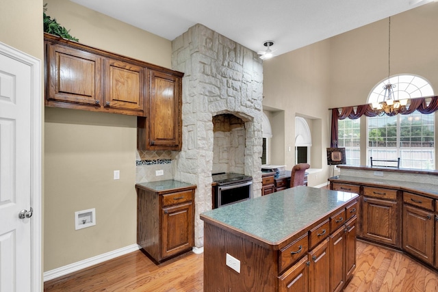 8 Calloway Ct, Mansfield, TX 76063 - kitchen featuring light wood finished floors, stainless steel range with electric cooktop, a chandelier, and a kitchen island