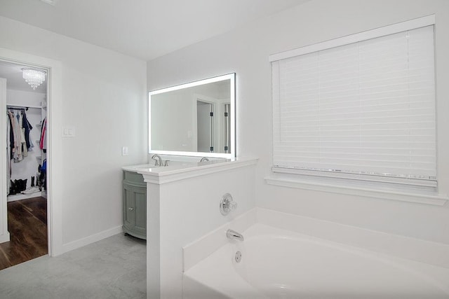 1117 Marcia Ln, Burleson, TX 76028 - bathroom with a bath, vanity, a spacious closet, and baseboards