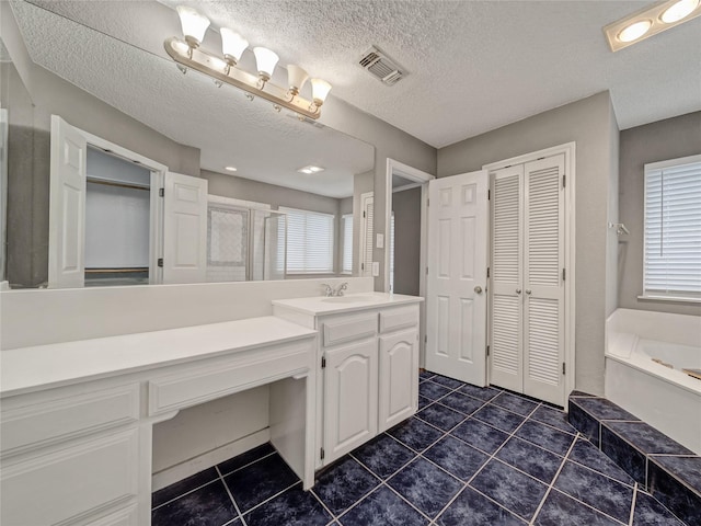 7900 Marsh Ct, Fort Worth, TX 76123 - full bath featuring a closet, vanity, a garden tub, tile patterned floors, and a textured ceiling